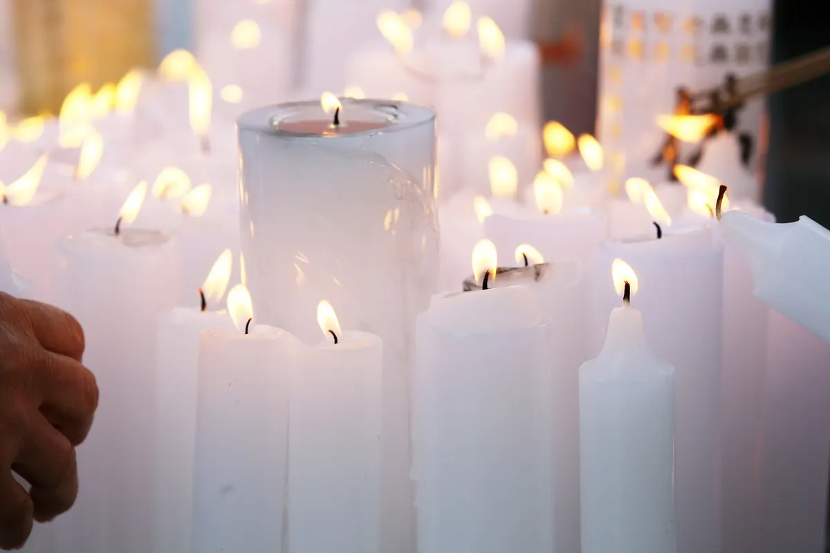 Rows of lit white candles with small warm flames at Jogyesa Temple in Seoul