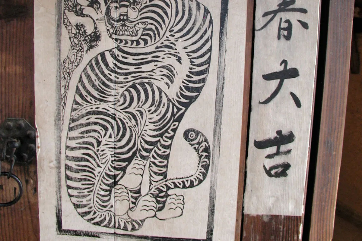 A hanok door at the Korean Folk Village with a tiger print and a spring sign from 立春大吉, the ipchun wish