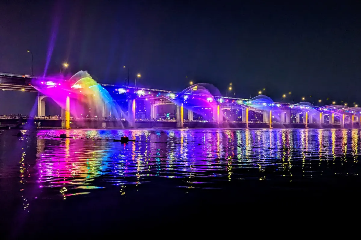 Banpo Bridge Moonlight Rainbow Fountain lit in rainbow colors over the Han River at night